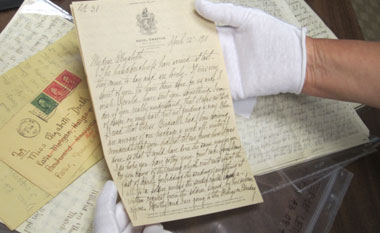 Image of historical document being held by a white glove